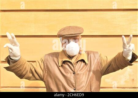 Alter Mann in medizinische Maske und Handschuhe Anti-Virus covid 19 älterer Mann zeigt Siegesgesten Stockfoto