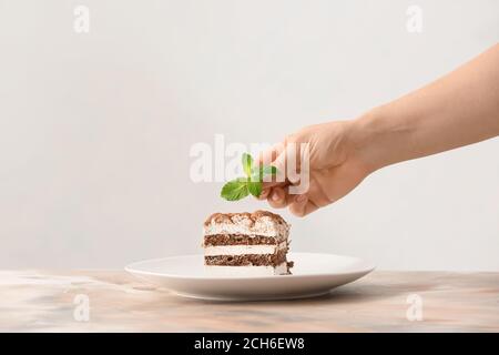 Frau bereitet leckere Tiramisu auf dem Tisch Stockfoto