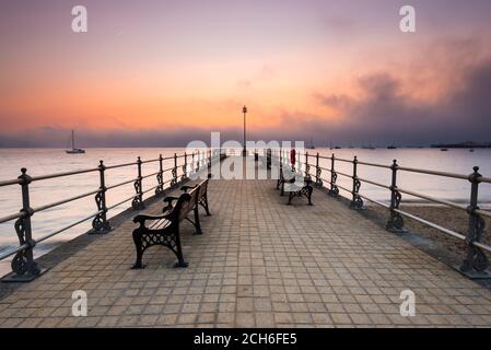 Swanage, Dorset, Großbritannien. September 2020. Wetter in Großbritannien. Eine Bank aus Nebel und Nebel rollt bei Sonnenaufgang über dem Meer und verdunkelt die aufgehende Sonne, die vom Banjo Pier in Swanage in Dorset aus betrachtet wird, während die Mini-Hitzewelle anhält. Bild: Graham Hunt/Alamy Live News Stockfoto