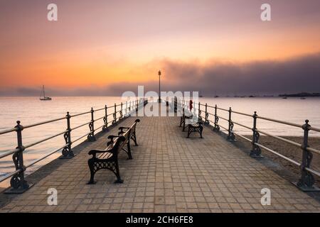 Swanage, Dorset, Großbritannien. September 2020. Wetter in Großbritannien. Eine Bank aus Nebel und Nebel rollt bei Sonnenaufgang über dem Meer und verdunkelt die aufgehende Sonne, die vom Banjo Pier in Swanage in Dorset aus betrachtet wird, während die Mini-Hitzewelle anhält. Bild: Graham Hunt/Alamy Live News Stockfoto