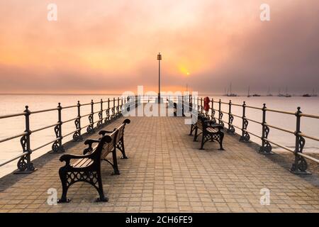 Swanage, Dorset, Großbritannien. September 2020. Wetter in Großbritannien. Eine Bank aus Nebel und Nebel rollt bei Sonnenaufgang über dem Meer und verdunkelt die aufgehende Sonne, die vom Banjo Pier in Swanage in Dorset aus betrachtet wird, während die Mini-Hitzewelle anhält. Bild: Graham Hunt/Alamy Live News Stockfoto