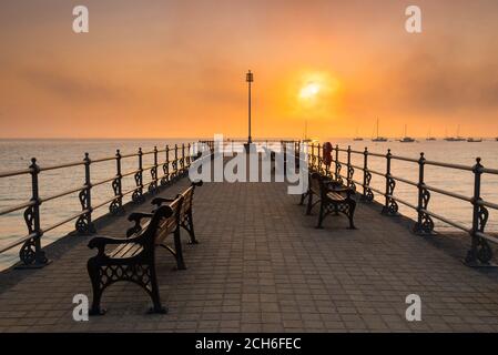 Swanage, Dorset, Großbritannien. September 2020. Wetter in Großbritannien. Bei Sonnenaufgang rollt Nebel über das Meer und verdeckt die aufgehende Sonne, die vom Banjo Pier in Swanage in Dorset aus betrachtet wird, während die Mini-Hitzewelle anhält. Bild: Graham Hunt/Alamy Live News Stockfoto