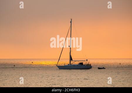 Swanage, Dorset, Großbritannien. September 2020. Wetter in Großbritannien. Eine Yacht wird gegen den nebligen Sonnenaufgang in Swanage in Dorset silhouettiert, während die Mini-Hitzewelle weitergeht. Bild: Graham Hunt/Alamy Live News Stockfoto
