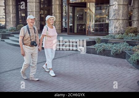 Fröhliches Senior-Touristen-Paar, das die Straße entlang schlentert Stockfoto