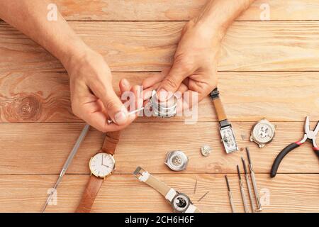 Uhrmacher repariert kaputte Uhr am Tisch Stockfoto