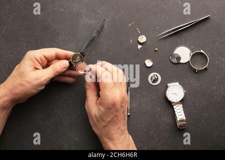 Uhrmacher repariert kaputte Uhr am Tisch Stockfoto