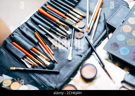 Make-up Artist Set. Ein professionelles Set Make-up Pinsel und eine Palette von Lidschatten in verschiedenen Farben in einer schwarzen Kosmetiktasche. Stockfoto