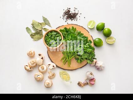 Brett mit frischer Petersilie, Pilzen und Gewürzen auf weißem Hintergrund Stockfoto