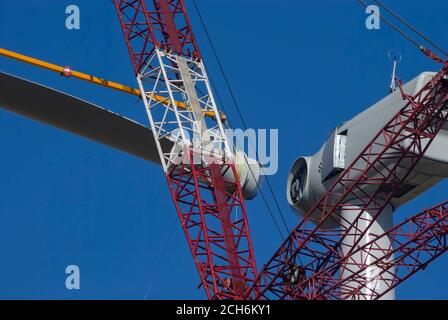 Riesiger Kran, der das Rotorblatt der Windenergieanlage hebt, um es während des Baus eines Windparks in Rio Vista, Kalifornien, in der Nähe von Sacramento, am Maschinenhaus zu befestigen Stockfoto