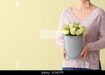 Frau mit Blumenstrauß aus schönen Blumen auf Farbhintergrund Stockfoto