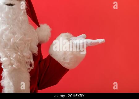 Santa Claus hält etwas auf Farbe Hintergrund Stockfoto