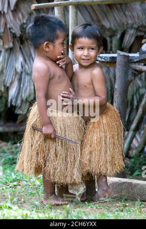 IQUITOS, PERU - 25. APRIL 2012 : Peruanische Jungen in Tradition Indische Grasröcke in einem Dorf in der Nähe von Iquitos am Amazonas in Peru. Stockfoto