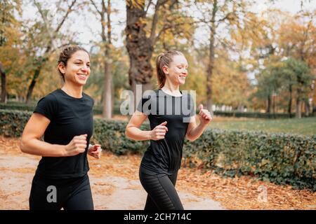 Ein paar Frauen, die draußen durch den Park rannten Stockfoto
