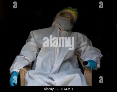 Erschöpfter Arzt in PSA Anzug Uniform in Stress auf schwarzem Hintergrund. Depression, müde Konzept. Stockfoto