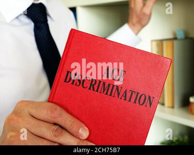 Ein Anwalt zeigt im Büro ein Buch mit Altersdiskriminierungsgesetz. Stockfoto