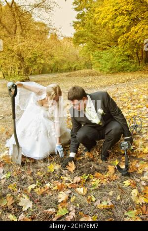 Braut und Bräutigam auf der Suche nach Ringen mit Metalldetektor in Der Wald Stockfoto