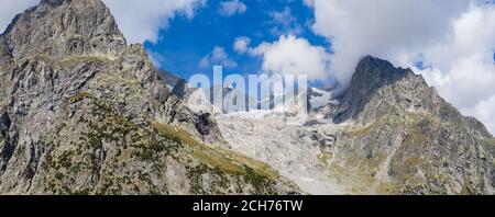 Panorama von einem alpinen Bergtal und Gipfeln. Hohe Berggipfel und ein Gletscher und Wasserfällen auf der italienischen Seite des Mont Blanc Massivs. Stockfoto