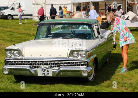 Eine junge Frau bewundert einen Ford Fairlane aus den 1950er Jahren auf der Decor Fair in Henley-on-Thames, Großbritannien Stockfoto