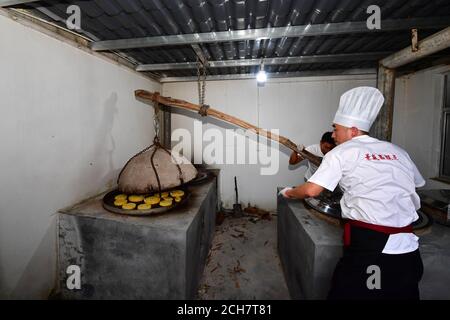 (200914) -- ZHENGZHOU, 14. September 2020 (Xinhua) -- Zhang Xu (R) backt Mondkuchen in der Mooncake Bäckerei Jingshengchang im Bezirk Xiayi, Shangqiu, Provinz Henan in Zentralchina, 13. September 2020. Im Alter von 31 Jahren ist Zhang Xu bereits Küchenchef von Jingshengchang, einer 1860 gegründeten Mondkuchen-Bäckerei in Henan. Die in Jingshengchang hergestellten Mooncakes zeichnen sich durch ihre knusprigen Krusten und ihre großzügige Füllung aus, gepaart mit einer akribischen Menge an Backwaren-Fertigkeiten, die Zhang seit dem Abitur 2007 zu erlernen begonnen hatte. "Unsere Backkunst ist ein großer Schatz", sagt Zhang. 'Ich werde mein tun Stockfoto