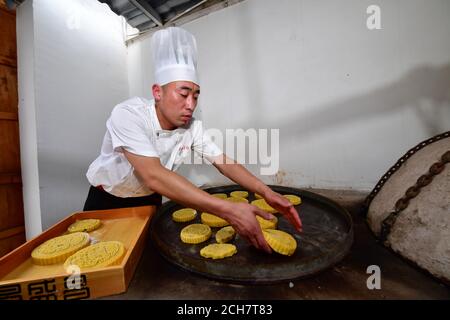 (200914) -- ZHENGZHOU, 14. September 2020 (Xinhua) -- Zhang Xu backt Mondkuchen in der Mondkuchen-Bäckerei Jingshengchang im Bezirk Xiayi, Shangqiu, Provinz Henan in Zentralchina, 13. September 2020. Im Alter von 31 Jahren ist Zhang Xu bereits Küchenchef von Jingshengchang, einer 1860 gegründeten Mondkuchen-Bäckerei in Henan. Die in Jingshengchang hergestellten Mooncakes zeichnen sich durch ihre knusprigen Krusten und ihre großzügige Füllung aus, gepaart mit einer akribischen Menge an Backwaren-Fertigkeiten, die Zhang seit dem Abitur 2007 zu erlernen begonnen hatte. "Unsere Backkunst ist ein großer Schatz", sagt Zhang. "Ich werde meinen Namen tun Stockfoto