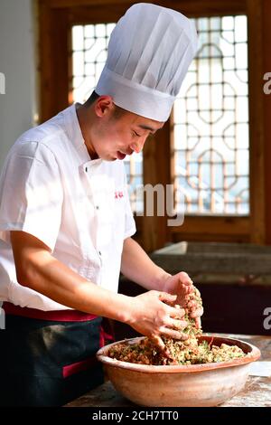 (200914) -- ZHENGZHOU, 14. September 2020 (Xinhua) -- Zhang Xu bereitet die Mooncake-Füllung in der Mooncake-Bäckerei Jingshengchang im Bezirk Xiayi, Shangqiu, Provinz Henan in Zentralchina, 13. September 2020 zu. Im Alter von 31 Jahren ist Zhang Xu bereits Küchenchef von Jingshengchang, einer 1860 gegründeten Mondkuchen-Bäckerei in Henan. Die in Jingshengchang hergestellten Mooncakes zeichnen sich durch ihre knusprigen Krusten und ihre großzügige Füllung aus, gepaart mit einer akribischen Menge an Backwaren-Fertigkeiten, die Zhang seit dem Abitur 2007 zu erlernen begonnen hatte. "Unsere Backkunst ist ein großer Schatz", sagt Zhang. „I'l Stockfoto