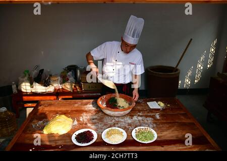 (200914) -- ZHENGZHOU, 14. September 2020 (Xinhua) -- Zhang Xu bereitet die Mooncake-Füllung in der Mooncake-Bäckerei Jingshengchang im Bezirk Xiayi, Shangqiu, Provinz Henan in Zentralchina, 13. September 2020 zu. Im Alter von 31 Jahren ist Zhang Xu bereits Küchenchef von Jingshengchang, einer 1860 gegründeten Mondkuchen-Bäckerei in Henan. Die in Jingshengchang hergestellten Mooncakes zeichnen sich durch ihre knusprigen Krusten und ihre großzügige Füllung aus, gepaart mit einer akribischen Menge an Backwaren-Fertigkeiten, die Zhang seit dem Abitur 2007 zu erlernen begonnen hatte. "Unsere Backkunst ist ein großer Schatz", sagt Zhang. „I'l Stockfoto