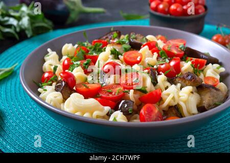 Pasta-Creste mit gegrillter Aubergine, Kirschtomaten und Kräutern. Köstlicher warmer Salat. Stockfoto