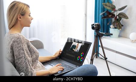 Frau Bearbeitung Video auf Laptop-Computer für ihr vlog. Frau, die zu Hause am Laptop arbeitet