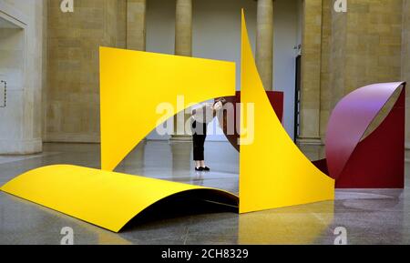 Ein Besucher steht in Phillip Kings Skulptur 'Instable Reel', 1970, während eine Ausstellung einer Auswahl seiner Arbeiten zur Feier seines 80. Geburtstages in der Tate Britain Gallery in London gezeigt wird. Stockfoto