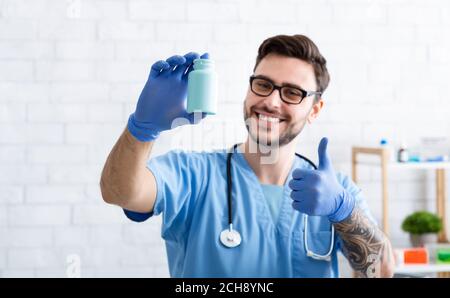 Glücklich Tierarzt doc zeigt Glas von Pillen und machen Daumen nach oben Geste in der Klinik, Raum für Design Stockfoto