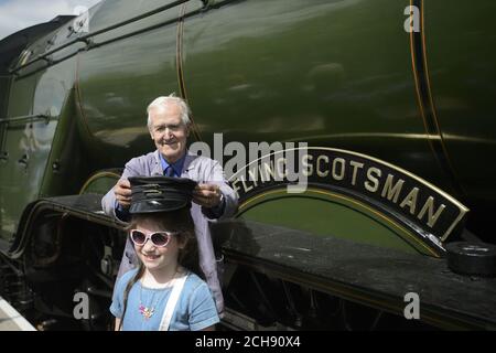 Motorfeuermann Gordon Hodgson, 77, aus Carlisle, legt seinen Hut auf einen Jungen, um ein Foto für ihre Mutter zu machen, als Flying Scotsman vom Bahnhof Edinburgh Waverley nach Tweedbank in the Borders am Bahnhof Tweedbank ankommt, Als es seine Reise durch Großbritannien fortsetzt, nachdem Network Rail eine Entscheidung zurückkehrte, Reisen kurzfristig abzusagen. Stockfoto