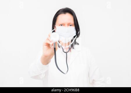 Porträt einer lächelnden Ärztin in Maske auf weißem Hintergrund. Stockfoto