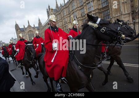 Mitglieder des The Household Cavalry Mounted Regiment kommen vor den Houses of Parliament zur Eröffnung des Parlaments im House of Lords im Palace of Westminster in London an. Stockfoto