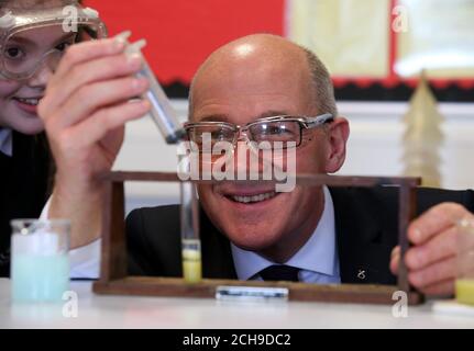 Stellvertretender erster Minister und neuer Bildungsminister John Swinney bei einem Besuch seiner ehemaligen Schule, der Forrester High School in Edinburgh, wo er sich mit der Schülerin Ellie Mackay für einen wissenschaftlichen Kurs zusammenschloss, während sie DNA-Extraktion in Kiwi-Früchten durchführten. Stockfoto