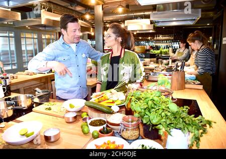 Jamie Oliver (links) kommt zu Cheryl an seiner Cookery School im Westfield Shopping Centre in London, als sie eine Facebook-Live-Veranstaltung starten, bei der Köche aus zehn Ländern die Zuschauer ermutigen, gesunde Gerichte von Grund auf zu kochen. Am Tag der Lebensmittelrevolution, der Teil der Kampagne zur Lebensmittelrevolution ist, die darauf abzielt, die Probleme der Unterernährung von Kindern und Adipositas anzugehen. Stockfoto