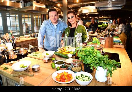 Jamie Oliver (links) kommt zu Cheryl an seiner Cookery School im Westfield Shopping Centre in London, als sie eine Facebook-Live-Veranstaltung starten, bei der Köche aus zehn Ländern die Zuschauer ermutigen, gesunde Gerichte von Grund auf zu kochen. Am Tag der Lebensmittelrevolution, der Teil der Kampagne zur Lebensmittelrevolution ist, die darauf abzielt, die Probleme der Unterernährung von Kindern und Adipositas anzugehen. Stockfoto