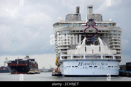 Ein Containerschiff passiert das größte Passagierschiff der Welt, MS Harmony of the Seas, im Besitz von Royal Caribbean, als es darauf wartet, Southampton zu verlassen. Stockfoto