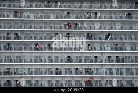 Gäste winken auf dem größten Passagierschiff der Welt, der MS Harmony of the Seas, die im Besitz von Royal Caribbean ist, als das Schiff Southampton verlässt. Stockfoto