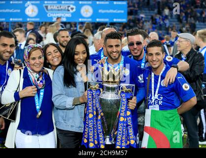 Riyad Mahrez von Leicester City und seine Familie stehen mit der Trophäe, während das Team den Sieg der Barclays Premier League feiert, nach dem Spiel im King Power Stadium, Leicester. Stockfoto