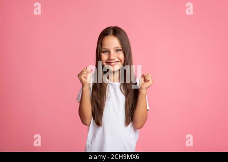 Spaß und Euphorie Konzept. Glückliches Mädchen, das Fäuste zusammenhält Stockfoto