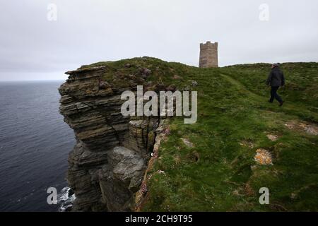Die Besucher wandern auf den Klippen hoch über dem Meer bei Marwick Head in Orkney entlang, wo der Turm steht, der zur Erinnerung an Lord Kitchener gebaut wurde.