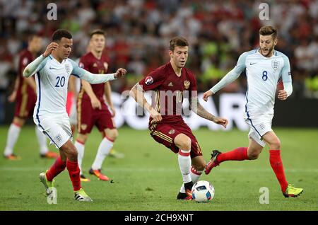 Russlands Fjodor Smolov (Mitte) kämpft mit Englands um den Ball DELE Alli (links) und Englands Adam Lallana (rechts) Stockfoto