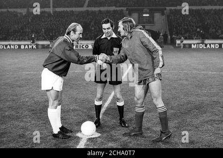 Die Mannschaftskapitäne Bobby Charlton (l.), Manchester United, Kapitän der britischen drei, und Gunter Netzer, Borussia Mönchengladbach und Westdeutschland, geben sich vor dem Spiel die Hände. Schiedsrichter ist Norman Burtenshaw. Stockfoto
