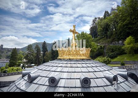 Lourdes, Frankreich: Das Heiligtum unserer Lieben Frau von Lourdes ist eines der größten Wallfahrtszentren in Europa. Die goldene Krone und das Kreuz auf dem Dom o Stockfoto