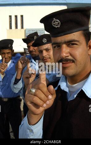 Offiziere der irakischen Polizei stimmen am Donnerstag, den 15. Dezember 2005, bei As Samawah in der irakischen Provinz Al Muthanna ab. Die Wahlen im Irak begannen heute reibungslos, als die Iraker zum ersten Mal unter ihrer neuen Verfassung an die Urnen gingen. In Wahllokalen in der Provinzhauptstadt Amara kam ein stetiger Strom von Menschen an, um ihre Stimmen abzugeben. Die britische Armee hat die Patrouille für den Tag fast völlig ausgesetzt, um deutlich zu machen, dass sie nicht versuchen, das Ergebnis in irgendeiner Weise zu beeinflussen. Aber der Oberbefehlshaber in der Provinz, Oberstleutnant Ben Edwards vom königlichen Schotten Dragoon Gu Stockfoto