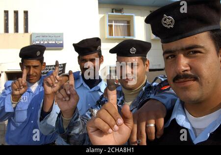 Offiziere der irakischen Polizei stimmen am Donnerstag, den 15. Dezember 2005, bei As Samawah in der irakischen Provinz Al Muthanna ab. Die Wahlen im Irak begannen heute reibungslos, als die Iraker zum ersten Mal unter ihrer neuen Verfassung an die Urnen gingen. In Wahllokalen in der Provinzhauptstadt Amara kam ein stetiger Strom von Menschen an, um ihre Stimmen abzugeben. Die britische Armee hat die Patrouille für den Tag fast völlig ausgesetzt, um deutlich zu machen, dass sie nicht versuchen, das Ergebnis in irgendeiner Weise zu beeinflussen. Aber der Oberbefehlshaber in der Provinz, Oberstleutnant Ben Edwards vom königlichen Schotten Dragoon Gu Stockfoto