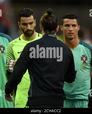 Der Portugiesen Cristiano Ronaldo (rechts) schüttelt die Hand des walisischen Gareth Bale (Mitte) während der UEFA Euro 2016, Halbfinalspiel im Stade de Lyon, Lyon. Stockfoto