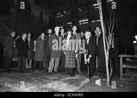 Der Geschäftsführer der Pressevereinigung Ian Yates (Mitte im Hintergrund) während einer Baumpflanzung in Erinnerung an Roy Partridge im Hof der St. Bride's Church. Stockfoto