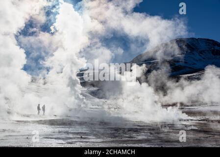 El Tatio Geysire in Chile, Silhouetten von Touristen unter den Dampft und Fumarolen bei Sonnenaufgang Stockfoto