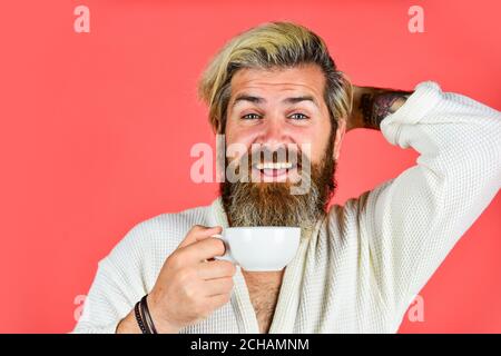 Tolle Zeit zu Hause. Morgenroutine. Mann mit verschlafenem Gesicht im Bademantel mit Tasse. Frühstück Konzept. Mann trinkt Kaffee am Morgen genießen Aroma. Fröhliche Hipster im Bademantel beim Kaffee. Stockfoto